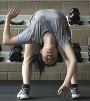 Student bending over backwards in yoga pose.