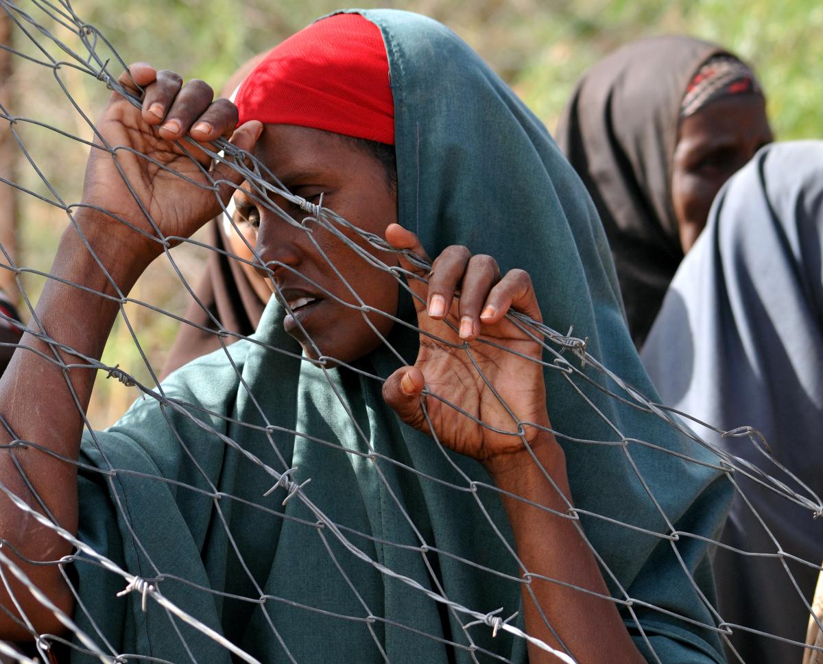 A woman clutches at a fence in a Dadaad, Somalia refugee camp, 2011.