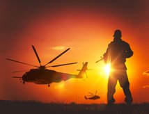 Helicopters and soldier at sunset