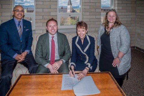 University of Denver Chancellor Rebecca Chopp signs a partnership with Andrew Hermalyn, executive vice president of strategic partnerships for 2U inc. They are joined by Dean Brent Chrite and Dean Amanda Moore McBride.