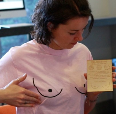 Julia Farrell, a founder of Boobi Butter, holds a wood-engraved educational guide that teaches women how to perform monthly self-breast exams.