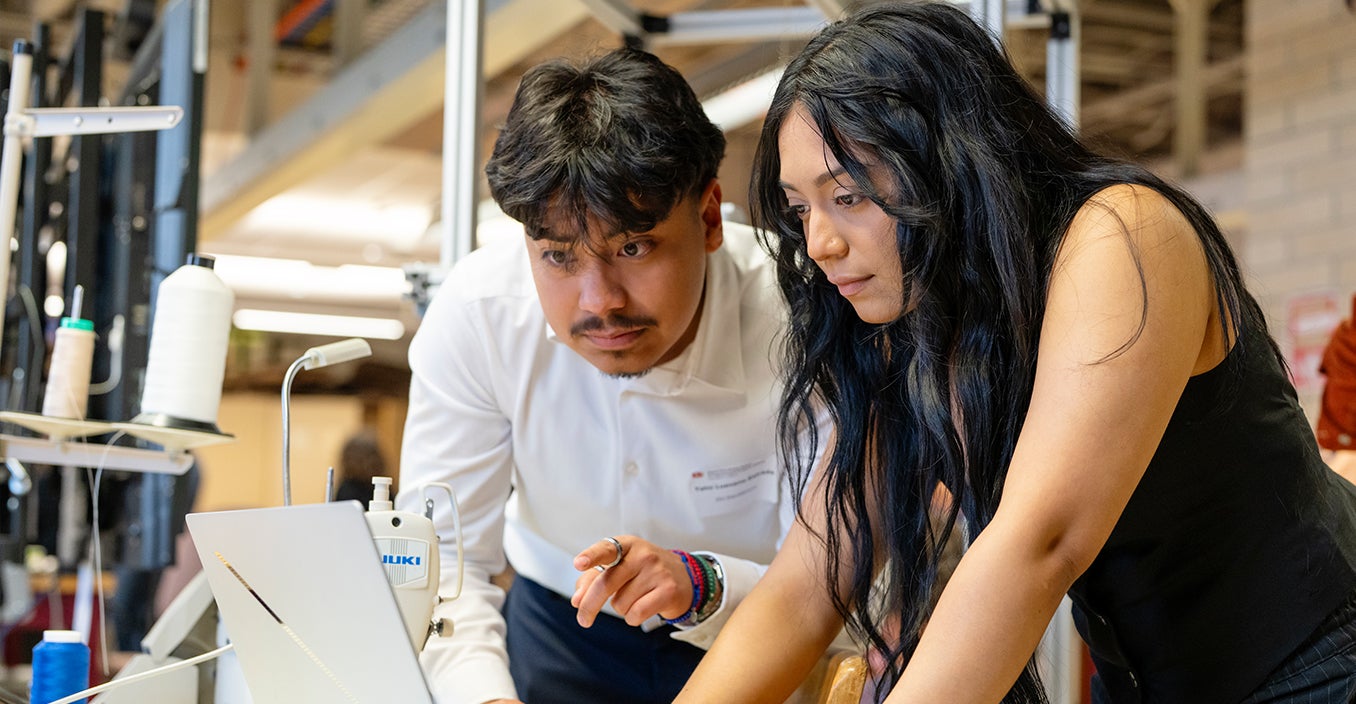 two persons looking at a laptop in a lab