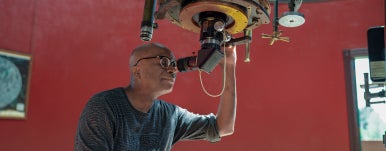 a person looking in the telescope at observatory