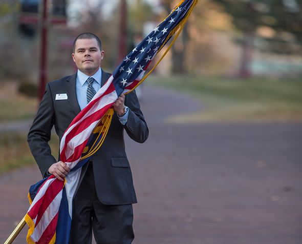 Veteran carrying U.S. flag.