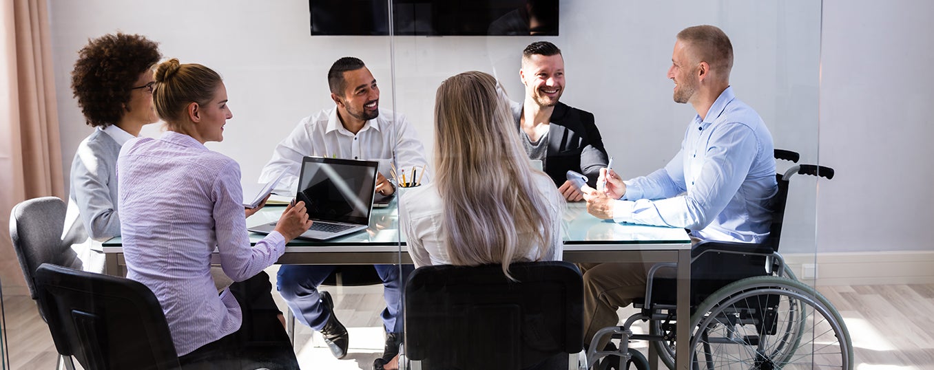 staff meeting together around a table