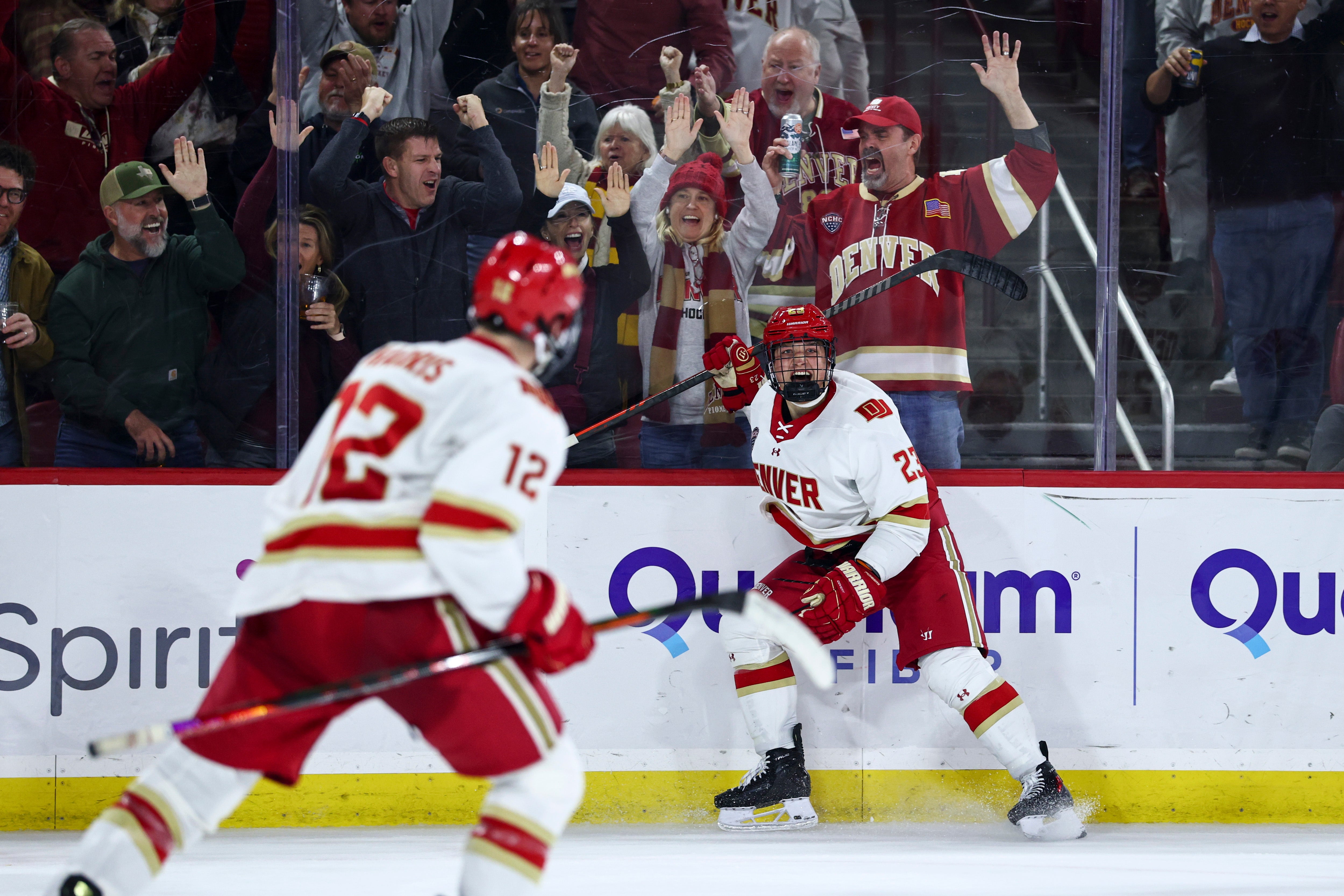 DU hockey players celebrate with fans behind the glass