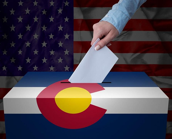 hand-puts-ballot-in-colorado-ballot-box