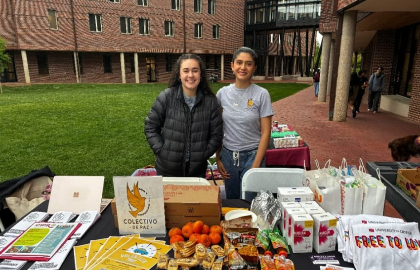 two women standing in front of a table with swag on it