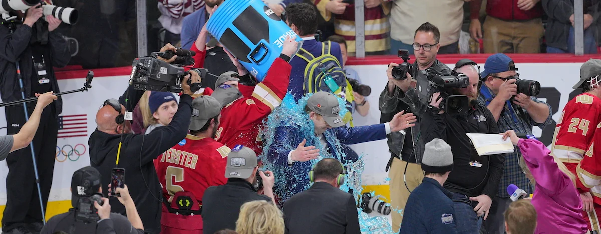 coach and players celebrate hockey championship