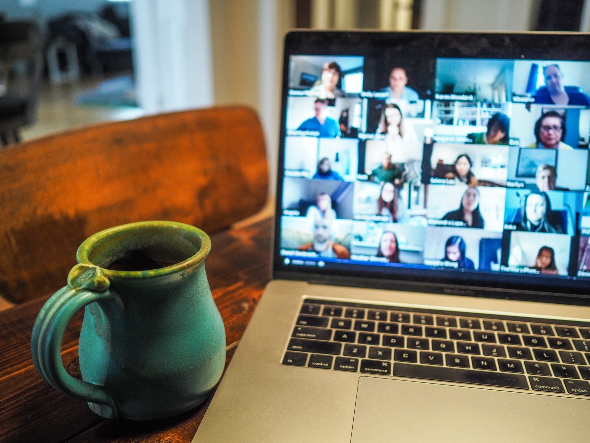 laptop open to zoom with coffee cup next to it