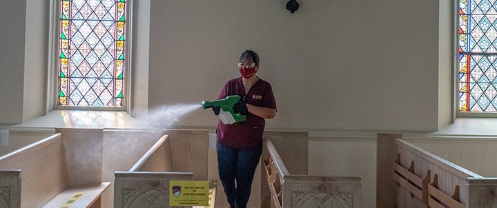 a worker spraying sanitizer in classroom