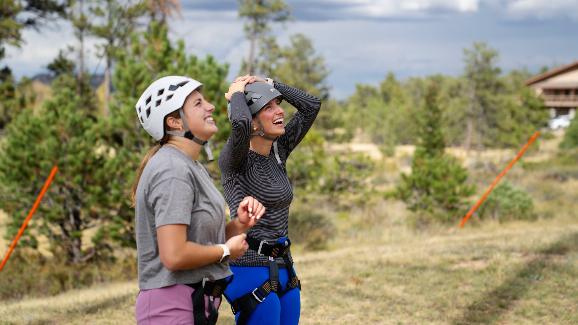 two students wearing climbing gear look up