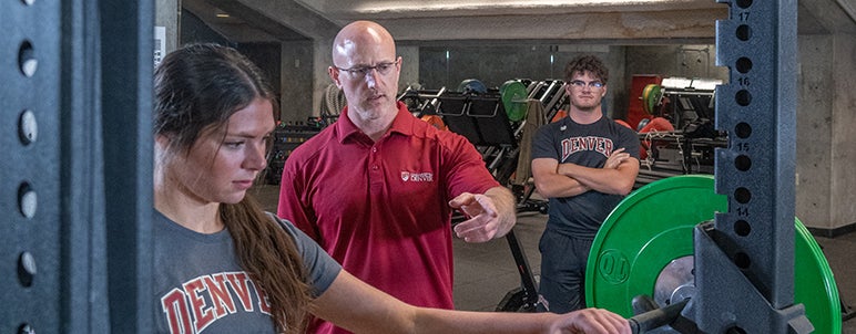 Brian coaching a student on weight lifting