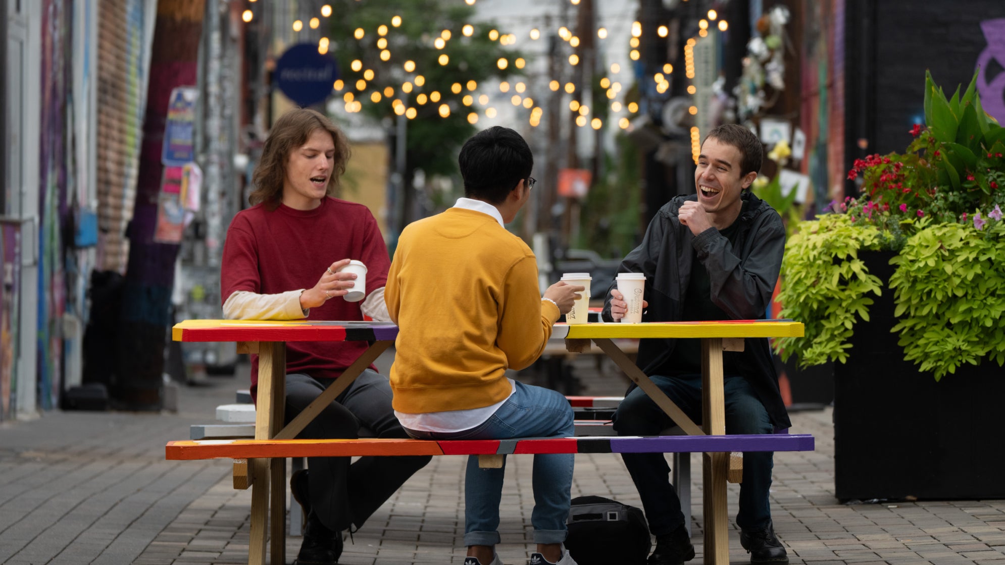 three students drink coffee in Denver downtown