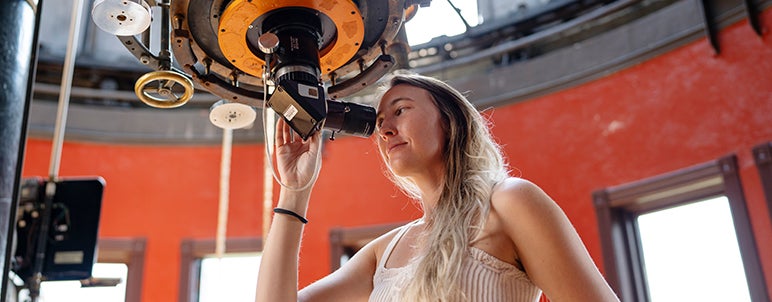 a student using telescope at observatory