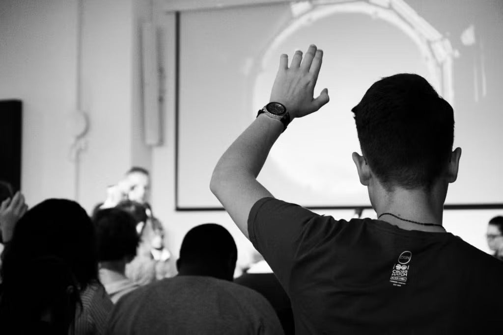a student raising hand in a class