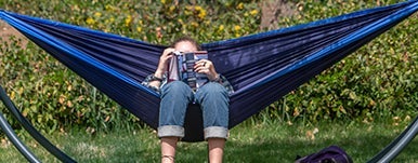 student reads a book in a hammock