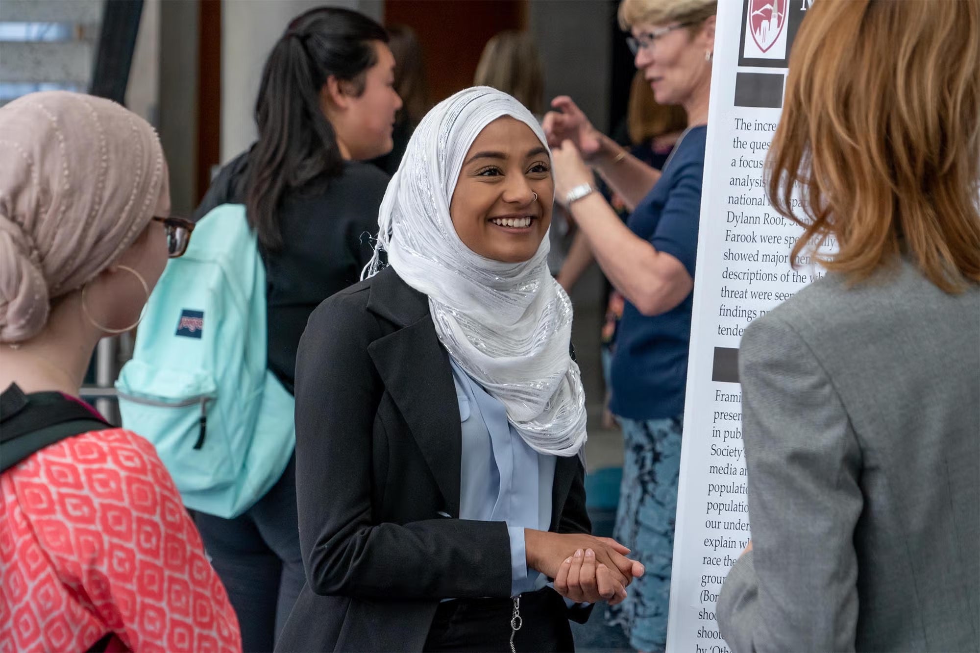 student of color giving a presentation at a DU student fair