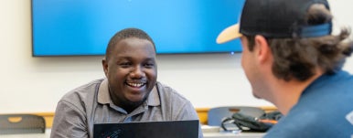 two students talk and smile at each other