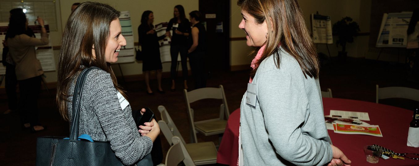 two women talking during a psychology networking event