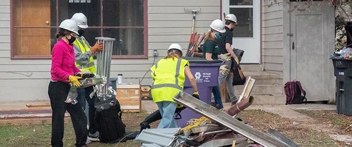 a group of people carrying construction materials