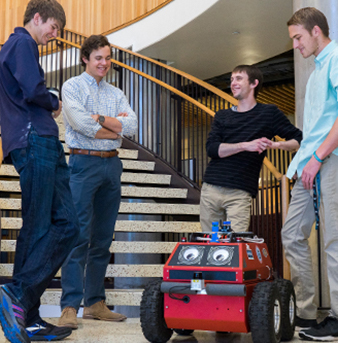 Students gather around a robot they built