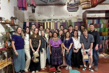 A group of DU students posing in a shop in Guatemala during an interterm trip
