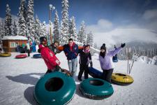five students pose together before a lap on the tubing hill