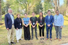 Four students pose for a group photo with three faculty members. 