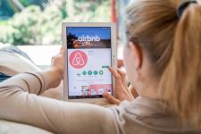 A woman looks at the airbnb app on her tablet