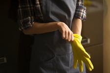 A woman puts on a yellow rubber glove