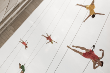 dancers suspended from buildings