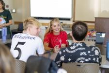 three students talking in a classroom