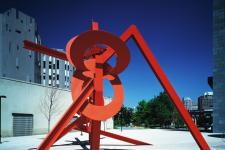 red painted steel abstract sculpture in front of a building