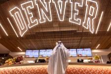 student dressed up as ghost under Denver neon sign