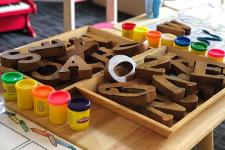 playdough and wooden letters in box on table