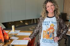 Woman standing with a shirt that has text that says only you can prevent wildfires