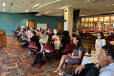 people sitting at tables listening to someone speaking