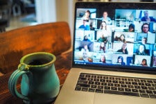 a laptop open to zoom and a coffee cup