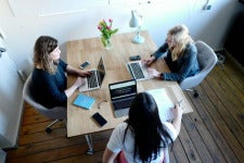 three women meet together with laptops