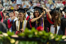 a row of students standing during commencement ceremony