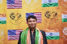 A man posed in front of a backdrop