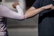 people cheer each other by touching elbow