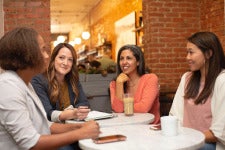 women meet and talk at a coffee shop