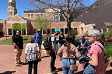 members of marcomm team standing outside on campus