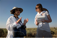 one person speaking and a second person holding a notebook and pen