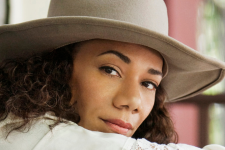 Martha Redbone in a large cream hat.