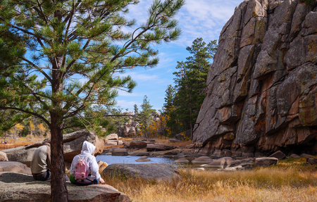 Students sit by Cliff Lake at the University of Denver's James C. Kennedy Mountain Campus