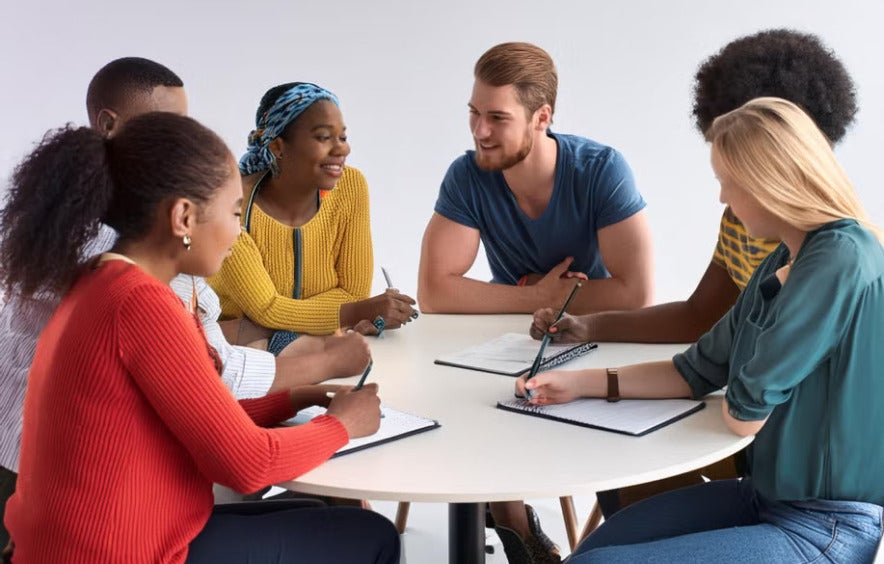 a group of people discussing and writing notes