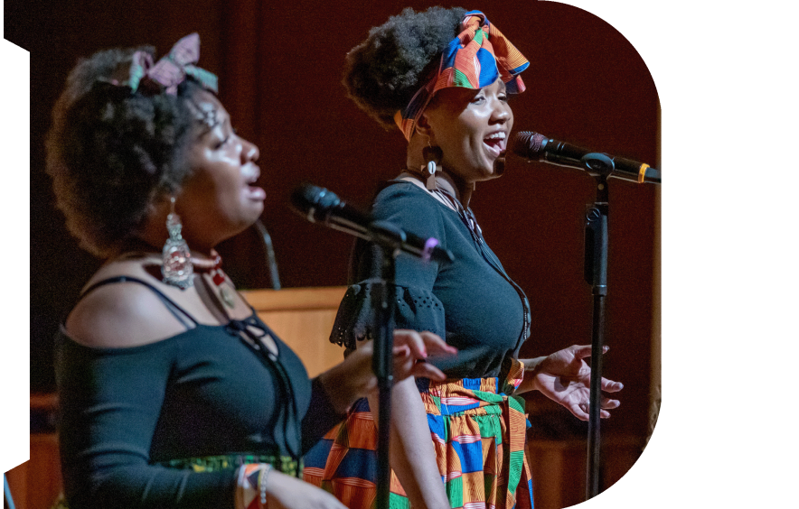 two people singing on stage
